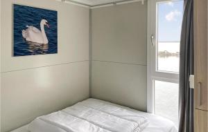 Bett in einem Zimmer mit einem Bild eines Schwans in der Unterkunft Nice Ship In Biddinghuizen With Kitchen in Biddinghuizen