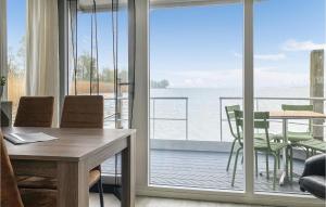 a dining room with a table and a view of the ocean at Nice Ship In Biddinghuizen With Kitchen in Biddinghuizen