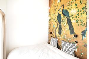 - une chambre avec une fresque murale représentant les oiseaux dans l'établissement PARIS Maison Exception Terrasse Jacuzzi Parking gratuit, à Saint-Ouen