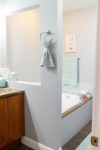ein Badezimmer mit einer Badewanne und einem Waschbecken in der Unterkunft Retro-inspired Content House In Patterson Park in Baltimore