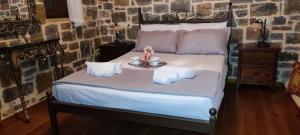 a bedroom with a bed with a tray of towels at FILEMA HOME (stone house) in Anópolis