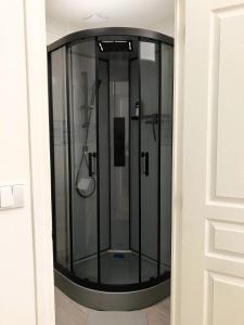 a glass shower in a room with a door at Makivka - A 5 min de Cognac - Maison entière avec 2 chambres in Boutiers-Saint-Trojan