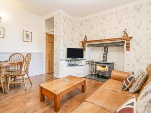 a living room with a couch and a fireplace at Beech Cottage in Ulverston