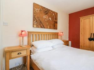 a bedroom with a bed and a table with a lamp at Beech Cottage in Ulverston