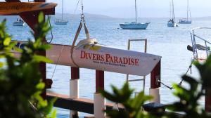 un cartello su un molo con barche in acqua di Divers Paradise Boutique Hotel a Bocas del Toro