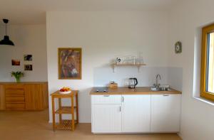 a kitchen with white cabinets and a sink and a table at Family Ranch Urlaub am Pferdehof 