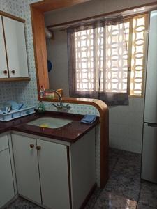 een kleine keuken met een wastafel en een raam bij Casa Schila in Tavernes de la Valldigna