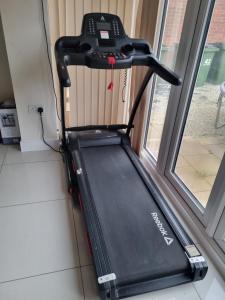 a treadmill is sitting next to a window at Deluxe room in a spacious house in Kirby Muxloe