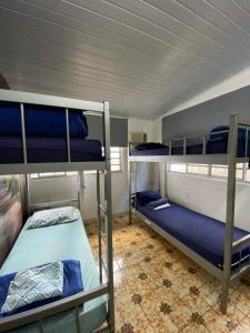 a room with three bunk beds in it at Rolds Hostel in Santos