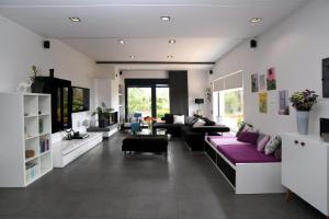 a living room with white walls and purple furniture at marathon family villa in Schinias