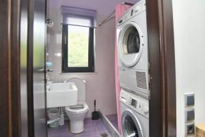 a bathroom with a washing machine and a washer at marathon family villa in Schinias +34 photos