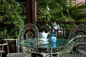 un tavolo di vetro con due vasi bianchi e blu sopra di Tatin - Hotel & Café in Mtskheta a Mtskheta