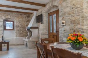 a dining room with a table and a stone wall at Heritage Villa Croc in Buje