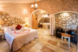 um quarto de hotel com uma cama e uma parede de pedra em Sierra Palomera 2 em Camañas