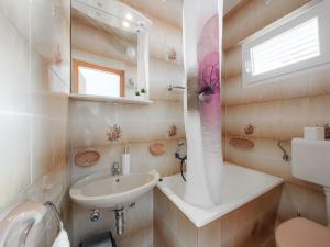 ein Badezimmer mit einem Waschbecken, einem WC und einem Spiegel in der Unterkunft Apartmani Rita in Baška Voda