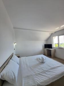 un letto bianco in una stanza con finestra di Hotel IMPERYUM a Baia Mare