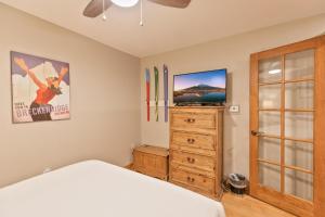 a bedroom with a bed and a dresser and a tv at Riverbend Centennial Run Condo: Ski In/Out in Breckenridge +31 photos