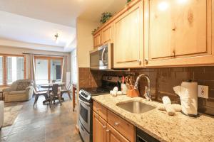 a kitchen with a sink and a stove top oven at Riverbend Centennial Run Condo: Ski In/Out in Breckenridge