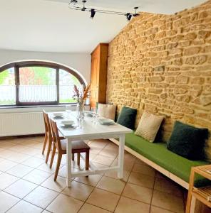 a dining room with a table and a couch at la trottinette vakantiehuis voor 5 tot 11 gasten vlakbij de Semois in Florenville
