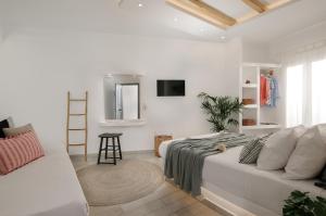 a white room with a bed and a couch at Naxos Hotel Poseidon in Naxos Chora