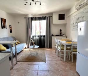 cocina y sala de estar con mesa y nevera en STUDIO ALGA en Algajola