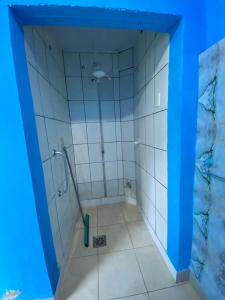 uma casa de banho com um chuveiro com paredes azuis em Rolds Hostel em Santos