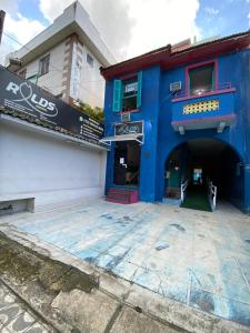 a blue building with a parking lot in front at Rolds Hostel in Santos