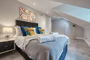 a bedroom with a large bed with blue pillows at Stunning 6 bed in Nottingham - Sleeps 16 in Nottingham