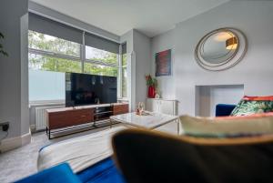uma sala de estar com um sofá e uma televisão em Stunning 6 bed in Nottingham - Sleeps 16 em Nottingham