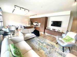 Brand New 3-Bedroom Condo in the Heart of Sidney في سيدني: غرفة معيشة مع أريكة بيضاء وطاولة