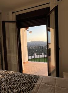 - une chambre avec une porte s'ouvrant sur un balcon dans l'établissement Casa Ilusión, à Frigiliana