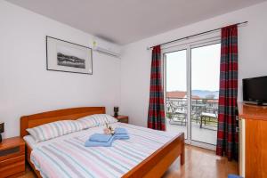 Schlafzimmer mit einem Bett, einem TV und einem Balkon in der Unterkunft Lulak Studio Apartments in Orebić