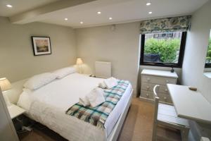 ein Schlafzimmer mit Bett, Schreibtisch und Fenster in der Unterkunft Brae Fell Cottage, Sebergham, Nr Caldbeck in Sebergham + 9 Fotos