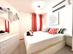 Schlafzimmer mit einem großen weißen Bett und roten Vorhängen in der Unterkunft Holiday Penthouse Jardin in Torrevieja