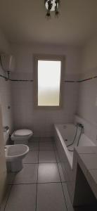 a bathroom with a tub and a toilet and a window at VILLA IN COLLINA VISTA MARE in Roseto degli Abruzzi