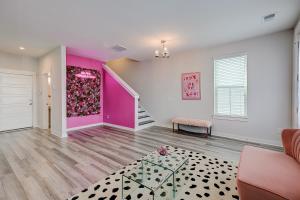 uma sala de estar com uma parede rosa e branca em Isla's Place em Charleston