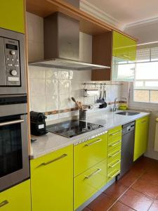 cocina amarilla con fregadero y fogones en Piso con jardín en Ribadeo, en Ribadeo