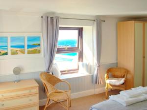 a bedroom with a window with a view of the ocean at Bishop Rock - Grl in Trevilley