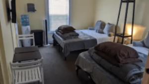 サンフランシスコにあるSunset Edwardian Bed and Breakfast At Golden Gate Park San Franciscoのベッド3台、椅子、テーブルが備わる客室です。
