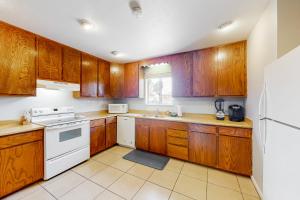 una cocina con armarios de madera y electrodomésticos blancos en Desert Treasure, en Phoenix