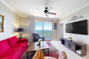 een woonkamer met een rode bank en een flatscreen-tv bij Splash Beach Resort 1206W in Panama City Beach