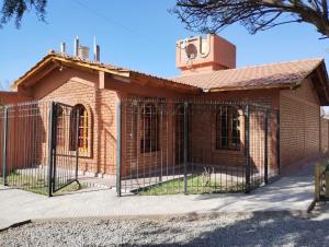 een bakstenen gebouw met een hek ervoor bij Casa Plantamura Vacaciones con Familia in La Cieneguita