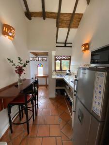 a kitchen with a table and a stainless steel refrigerator at Cabañas Sol y Luna in Villa de Leyva