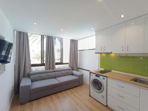 a living room with a couch and a washing machine at koka vacations 308 Playa del inglés in San Bartolomé de Tirajana