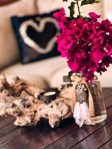 un jarrón lleno de flores rosas en una mesa en GREEN LAGOON, en Calpe