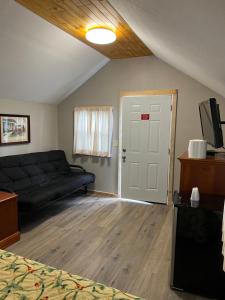 a living room with a black couch and a door at Doray Motel Lake George in Lake George