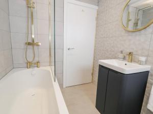 a bathroom with a tub and a sink and a mirror at Melody in Cemaes Bay +34 photos