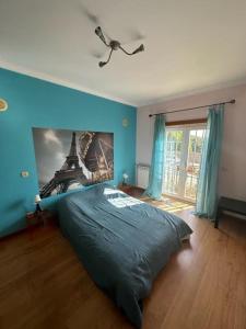 um quarto com uma cama com um quadro da Torre Eiffel em Casa Jasmim em Azeitao