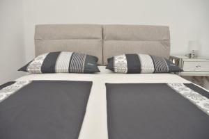 a bed with two pillows on top of it at Apartment Josip 2 in Tribunj