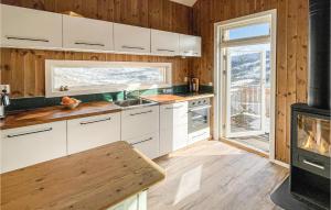 a kitchen with white cabinets and a stove with a fireplace at Awesome Home In len With Wifi And 2 Bedrooms in Ålen